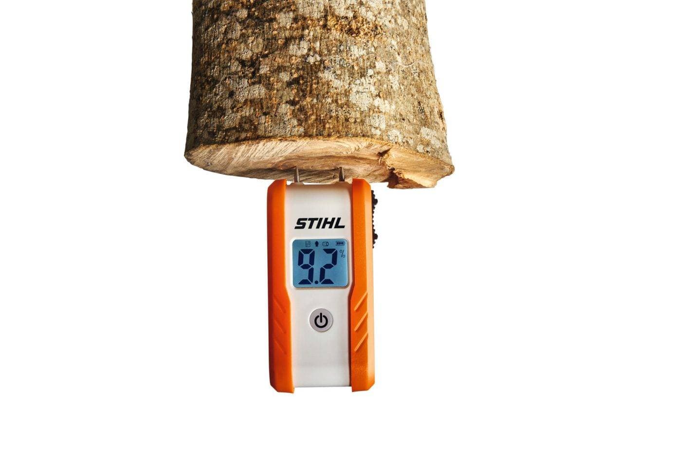 Kontaktní vlhkoměr STIHL při měření vlhkosti polena